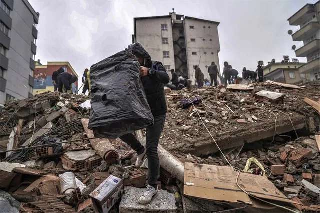 People and emergency teams search for people in the rubble in a destroyed building in Gaziantep, Turkey, Monday, February 6, 2023. A powerful quake has knocked down multiple buildings in southeast Turkey and Syria and many casualties are feared. (Photo by Mustafa Karali/AP Photo)