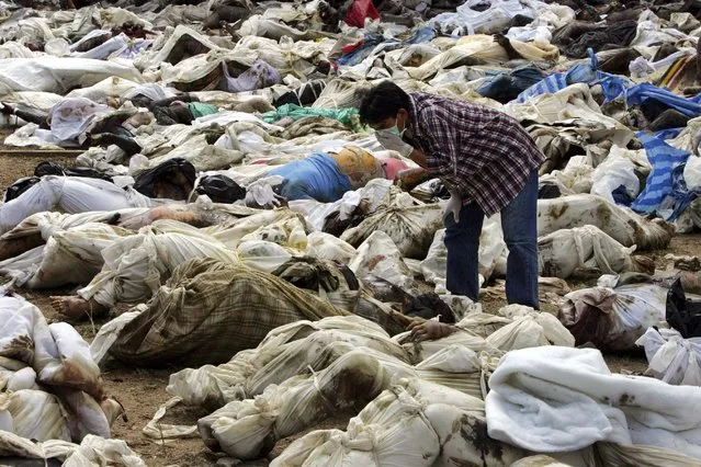 A Thai man searches for his relative amid hundreds of corpses in a temple off the coast of Ban Muan, Thailand in this December 29, 2004 file photo. (Photo by Reuters/Stringer)