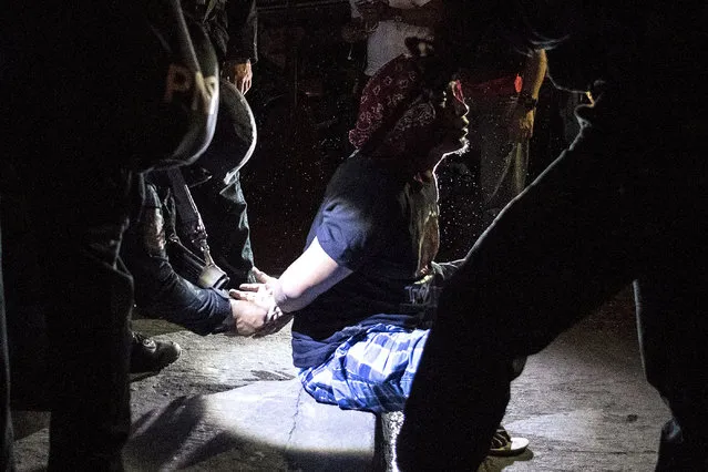 Philippine Drug Enforcement Agency (PDEA) agents and police arrest an alleged drug dealer during a drug raid in Maharlika Village, Taguig, south of Manila on February 28, 2018. The drug raid was conducted to arrest five drug dealers, but only two were captured. Philippine President Rodrigo Duterte' s war on drugs has left nearly 4,000 drug suspects dead and seen human rights groups claim he was responsible for a crime against humanity. The anti- drugs campaign enjoys popular support while the fiery- tongued Duterte has rejected any criticism of his human rights record. (Photo by Noel Celis/AFP Photo)