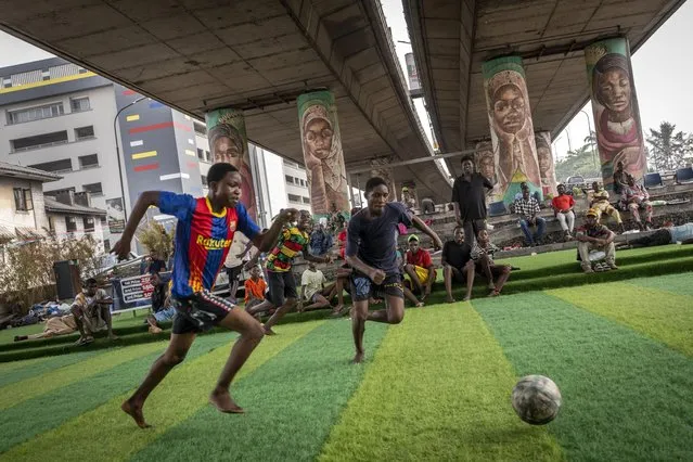 Youth play football underneath a highway bridge on Ikoyi Island, Lagos, Nigeria, Thursday, February 23, 2023. (Photo by Sunday Alamba/AP Photo)