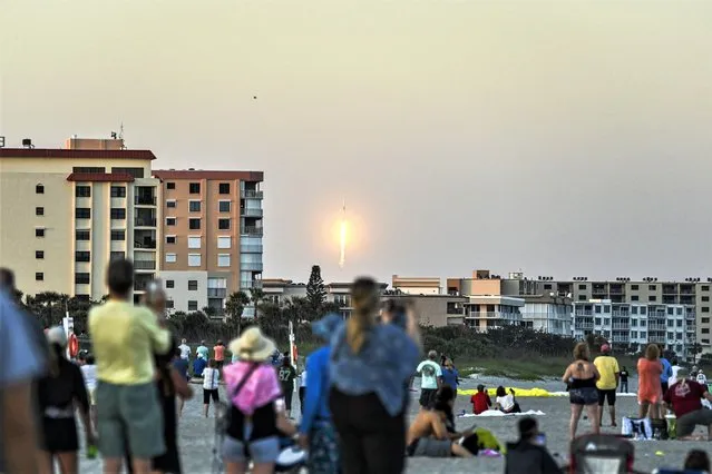 People look at the launch of a SpaceX Falcon 9 rocket carrying 21 second-generation Starlink satellites from Space Launch Complex 40 at NASA's Kennedy Space Center, in Cocoa Beach, Florida, on February 27, 2023. (Photo by Chandan Khanna/AFP Photo)