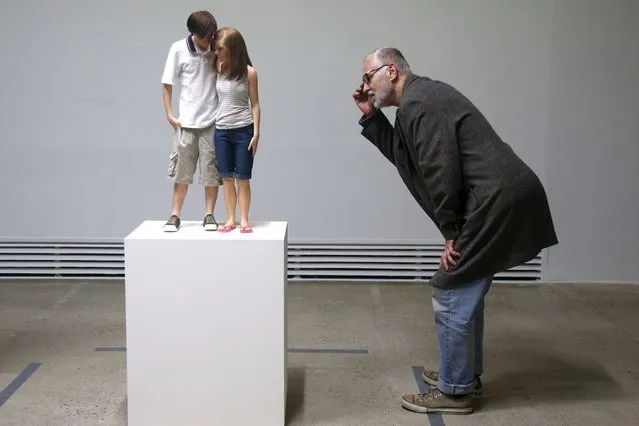 A visitor looks at a sculpture entitled “Young Couple, 2013” by artist Ron Mueck during the press day for his exhibition at the Fondation Cartier pour l'art contemporain in Paris April 15, 2013. The exhibition will run from April 16 to September 29, 2013. (Photo by Charles Platiau/Reuters)