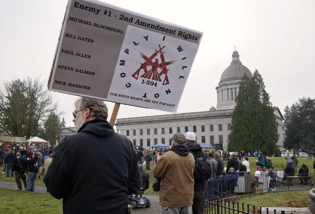 A man carries a sign as gun rights advocates rally against Initiative 594 at the state capitol in Olympia, Washington December 13, 2014. (Photo by Jason Redmond/Reuters)