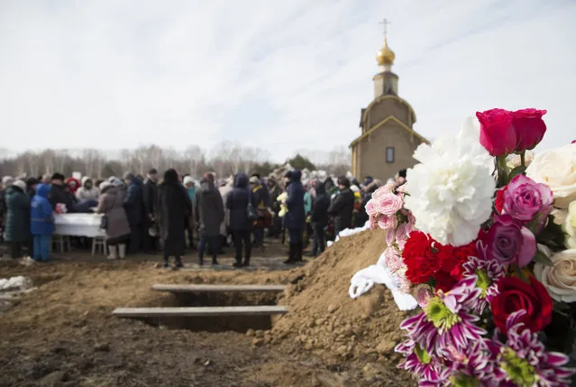 People attend a funeral of a victim of a shopping mall fire at a cemetery in Kemerovo, Russia March 28, 2018. (Photo by Maksim Lisov/Reuters)