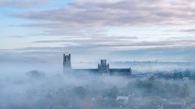 The picture dated April 9, 2025 shows early morning mist shrouding majestic Ely Cathedral in Cambridgeshire, UK. The Norman cathedral lived up to its nickname The Ship of the Fens as it appeared to float on the mist of the surrounding marshes. (Photo by Bav Media)