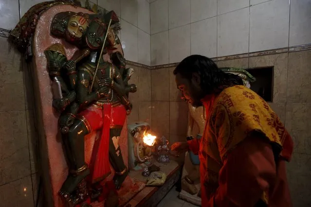 Ramnaath Mahraj holds an oil lamp to offer prayers in front of deities, during the Hindu festival of Diwali at the Shri Panchmukhi Temple in Karachi, Pakistan November 11, 2015. (Photo by Akhtar Soomro/Reuters)