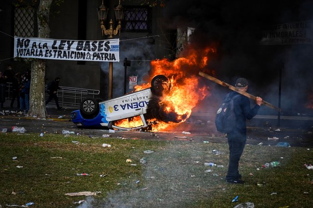 A car burns during a protest near the National Congress, on the day Senators debate Argentina's President Javier Milei's economic reform bill, known as the “omnibus bill”, in Buenos Aires, Argentina, on June 12, 2024. (Photo by Mariana Nedelcu/Reuters)
