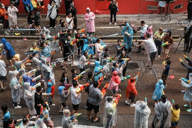 A cameraperson is sprayed by revellers in a water fight during Songkran Festival celebrations, in Hong Kong, China on April 9, 2023. (Photo by Lam Yik/Reuters)