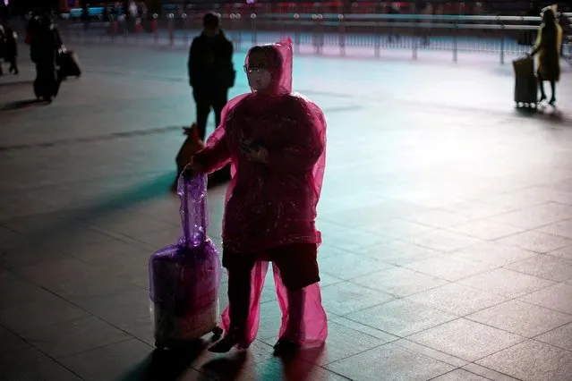 A woman wears a face mask and plastic raincoat as a protection from coronavirus at Shanghai railway station, in Shanghai, China on February 17, 2020. (Photo by Aly Song/Reuters)