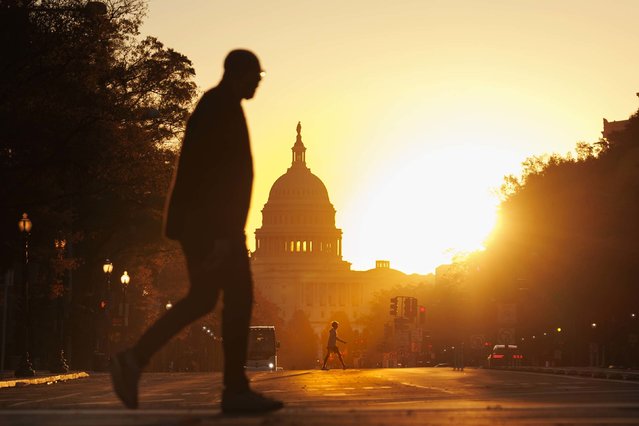 Pedestrians walks along Pennsylvania Avenue near the U.S. Capitol during sunrise on November 5, 2025 in Washington, DC. The record for longest shutdown in the U.S. Government was broken Wednesday as it entered its 36th day. (Photo by Tom Brenner/Getty Images)