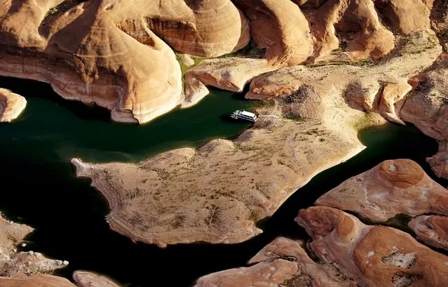 A houseboat camps on the shore in shallow water in a canyon at Lake Powell near Page, Arizona, May 26, 2015. (Photo by Rick Wilking/Reuters)
