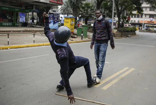 A Kenyan policeman running to arrest a protester slips and falls over just as he reaches him, before proceeding to arrest him, during a demonstration in downtown Nairobi, Kenya Tuesday, July 7, 2020. Kenyan police have fired tear gas and detained scores of protesters who were demanding an end to police brutality. (Photo by Brian Inganga/AP Photo)