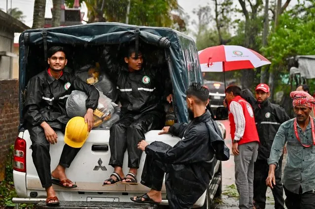 Members of Red Crescent Society sit in a vehicle loaded with relief material in Teknaf on May 14, 2023, after the cyclone Mocha's landfall. (Photo by Munir Uz Zaman/AFP Photo)