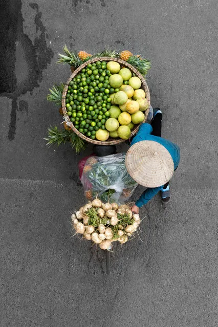“I wait on a couple of bridges in Hanoi and some restaurants with a balcony for hours on end to capture the street vendors. I love to see how the women have stored the fruits and vegetables on the bikes”. (Photo by Loes Heerink/The Guardian)