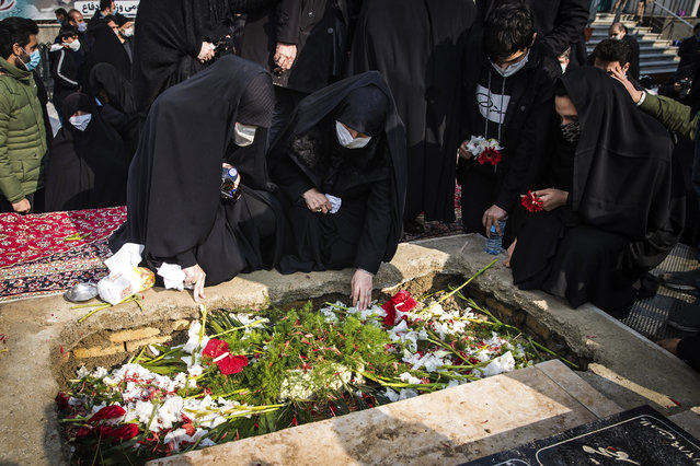 People pray at the grave of Mohsen Fakhrizadeh, a scientist who was killed on Friday, during his burial in Tehran, Iran, Monday, November 30, 2020. Iran held the funeral service Monday for the slain scientist who founded its military nuclear program two decades ago, with the Islamic Republic's defense minister vowing to continue the man's work “with more speed and more power”. (Photo by Hamed Malekpour/Tasnim News Agency via AP Photo)