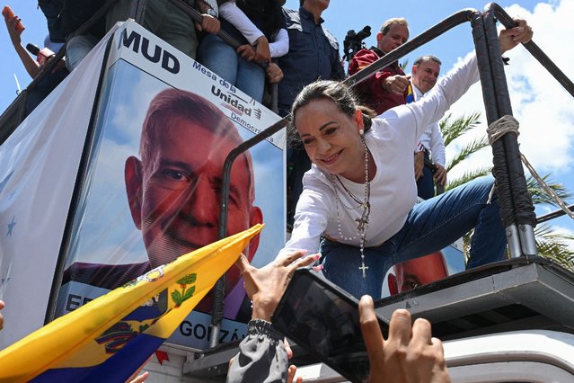 Venezuelan opposition leader Maria Corina Machado greets supporters from atop a truck during a demonstration to protest over the presidential election results, in Caracas on August 3, 2024. Venezuela braced for fresh protests after President Nicolas Maduro's disputed election victory was ratified on the eve – and a growing number of nations recognized his opposition rival as the true winner. (Photo by Federico Parra/AFP Photo)