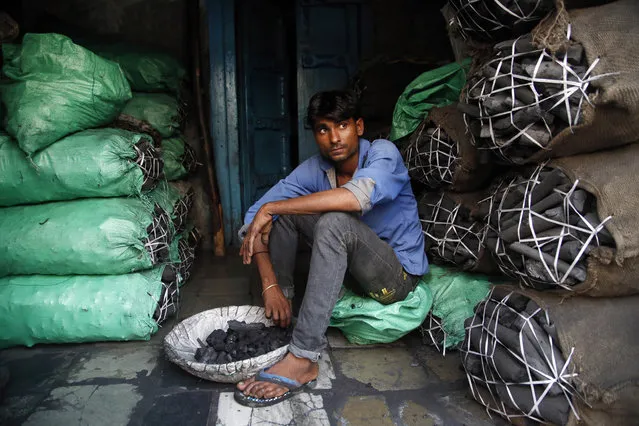 A worker at a retail coal store awaits customers in Mumbai, India, Thursday, Deember.3, 2015. An Indian delegate at U.N. climate talks says India will be able cut back on its carbon emissions if money is made available to boost renewable energy in an envisioned climate agreement in Paris.India's negotiators want to make sure that any deal in Paris doesn't restrict India's ability to expand its economy and electricity access to about 300 million people who currently have none. (Photo by Rajanish Kakade/AP Photo)
