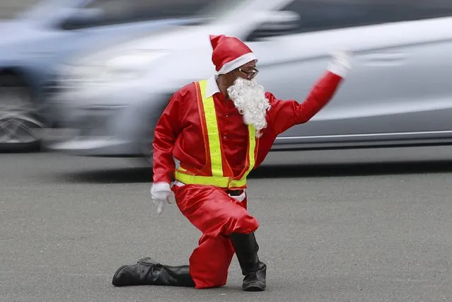 Traffic enforcer Ramiro Hinojas wears a Santa Claus costume while directing traffic flow at a busy intersection in Pasay city, metro Manila, December 12, 2015. (Photo by Romeo Ranoco/Reuters)