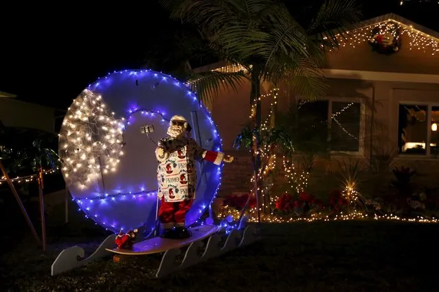 A Santa Claus taking a selfie on a surfboard is seen in the yard of a home in the Sleepy Hollow area of Torrance, California, United States, December 15, 2015. (Photo by Lucy Nicholson/Reuters)