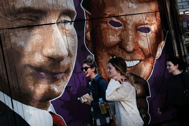 A mural depicting a winking Vladimir Putin taking off his Donald Trump mask is painted on a storefront outside of the Levee bar in Brooklyn on February 25, 2017 in New York City. (Photo by Spencer Platt/Getty Images)