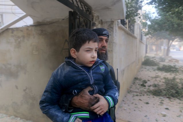 A rescue worker holds an injured boy after what activists said were airstrikes carried out by the Russian air force in Idlib city, Syria December 20, 2015. (Photo by Ammar Abdullah/Reuters)
