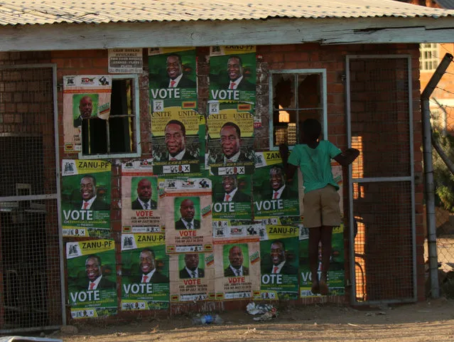 A boy plays next to election posters at White City Stadium where Zimbabwe's President Emmerson Mnangagwa escaped unhurt after an explosion rocked the stadium, in Bulawayo, Zimbabwe, June 23, 2018. (Photo by Philimon Bulawayo/Reuters)