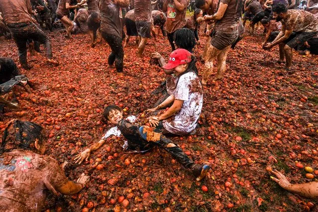 Children participate in the tenth annual Tomato Fight Festival, known as “Tomatina”, in Sutamarchan, Boyaca Department, Colombia, on June 11, 2023. This year's festival is the first held since the lifting of the COVID-19 coronavirus pandemic restrictions. (Photo by Juan Barreto/AFP Photo)