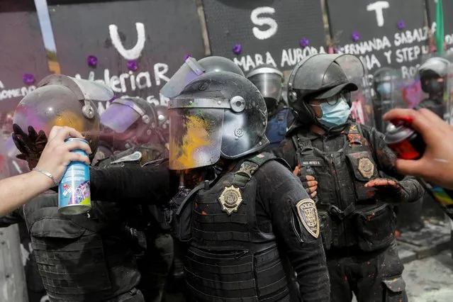 Protesters spray paint on police officers during a protest to mark International Women's Day in Mexico City, Mexico, March 8, 2021. (Photo by Mahe Elipe/Reuters)