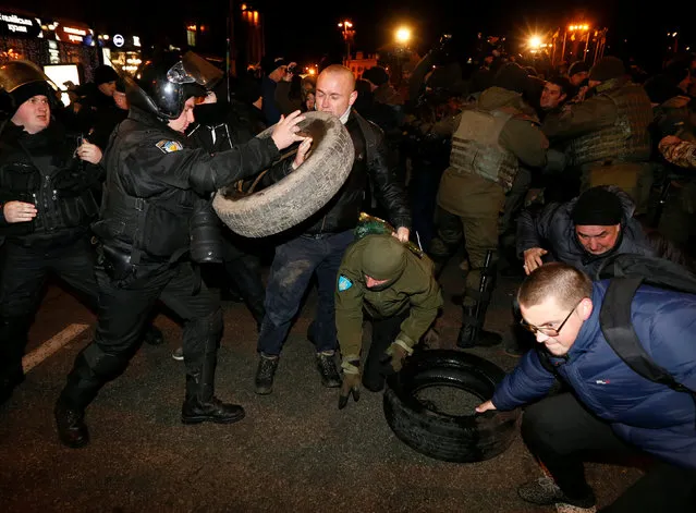 Policemen and law enforcement personnel block activists of nationalist groups and their supporters, who mark the anniversary of the 2014 Ukrainian pro-European Union (EU) mass protests on the Day of Dignity and Freedom in central Kiev, Ukraine, November 21, 2016. (Photo by Valentyn Ogirenko/Reuters)