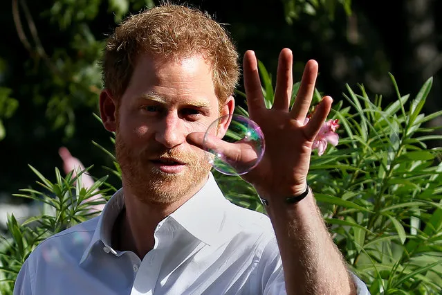Prince Harry tries to catch a bubble as he attends a charity event during his official visit in St. John's, Antigua November 21, 2016. (Photo by Carlo Allegri/Reuters)