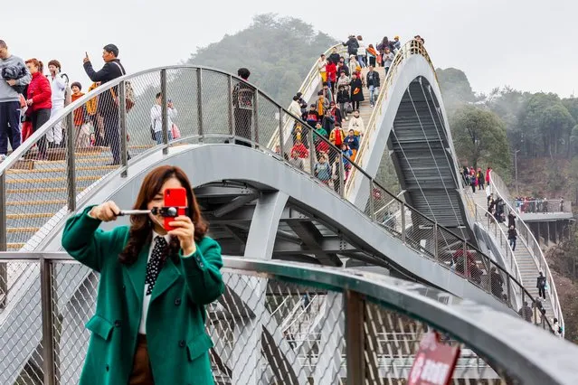 Tourists walk on Ruyi Bridge at Shenxianju Scenic Area on March 9, 2021 in Taizhou, Zhejiang Province of China. (Photo by Wu Linwu/VCG via Getty Images)