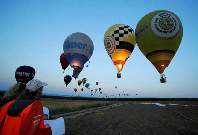Judges watch competitors approaching a target during the FAI World Hot Air Balloon Championship near Gross-Siegharts, Austria on August 20, 2018. (Photo by Heinz-Peter Bader/Reuters)