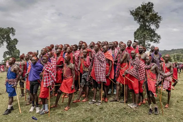 A group of Maasai men observe the ceremonial activities at the center of the ceremonial site during the Eunoto ceremony in a remote area near Kilgoris, Kenya on August 18, 2023. Hundreds of young Maasai take part in the Eunoto ceremony, a rite of passage that marks the transition from Moran (young warrior) to adulthood as junior elders. This ceremony is held by every clan once in a generation -every 8 to 10 years- and marks a new age-set. Eunoto, Enkipataa and Olng'esherr are the three main Maasai rites of passage that have been inscribed since 2018 on the Urgent Safeguardiang List of Intangible Cultural Heritage by UNESCO. (Photo by Luis Tato/AFP Photo)