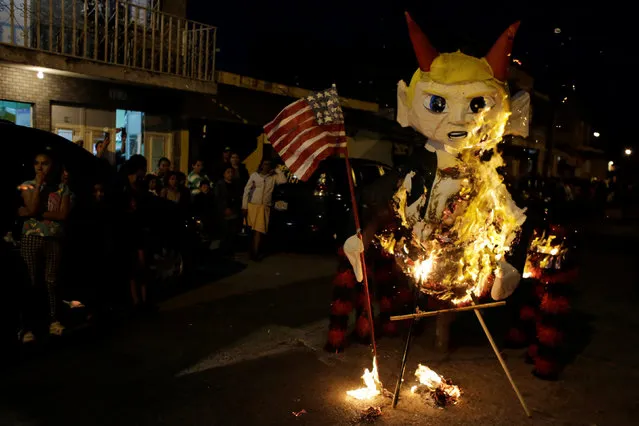 A pinata representing U.S. President-elect Donald Trump as a devil burns during the traditional Burning of the Devil festival, ahead of Christmas in Guatemala City, Guatemala December 7, 2016. (Photo by Luis Echeverria/Reuters)