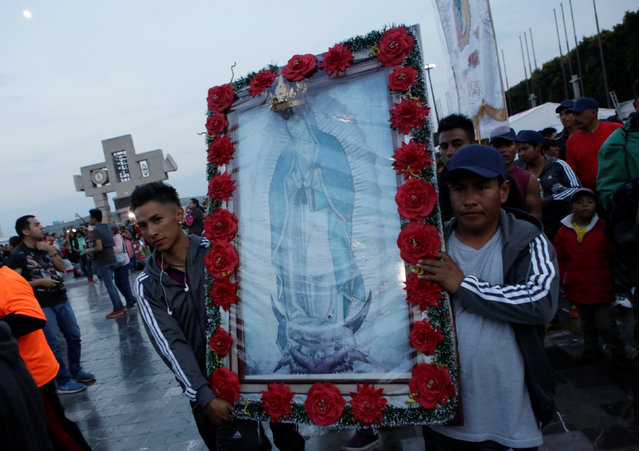 Pilgrims carry an image of the Virgin of Guadalupe as they arrive at the Basilica of Guadalupe during the annual pilgrimage in honor of the Virgin of Gudalupe, patron saint of Mexican Catholics, in Mexico City, Mexico December 11, 2016. (Photo by Henry Romero/Reuters)