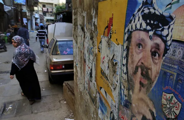 In this Thursday, May 4, 2017 photo, a woman walks past a poster of the late Palestinian leader Yasser Arafat, in the Bourj al-Barajneh Palestinian refugee camp in Beirut, Lebanon. (Photo by Bilal Hussein/AP Photo)