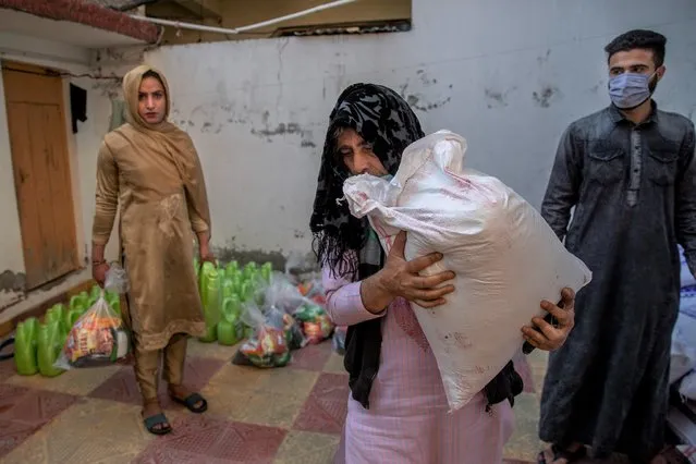 Bilal Ahmed, a transgender Kashmiri, carries a bag of rice distributed as food handout by a group in Srinagar, Indian controlled Kashmir, Thursday, May 27, 2021. Life has not been easy for many of Kashmir's transgender people. Most are ostracized by families and bullied in society. Living in the shadows of conflict, coupled with the recent crisis of the pandemic, pushed the community further to the margins. (Photo by Dar Yasin/AP Photo)