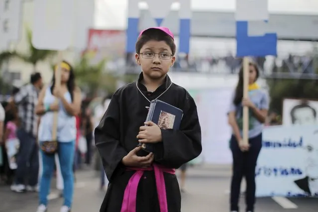 A child dresses up like the late Archbishop Oscar Arnulfo Romero during a march ahead of the 35th anniversary of his assassination in San Salvador March 21, 2015. Salvadoran Archbishop Romero, who was murdered by a right-wing death squad in 1980 and is an icon of the Roman Catholic Church in Latin America, had died as a martyr and will be beatified on May 23, the Vatican said. (Photo by Jose Cabezas/Reuters)