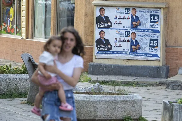 A pedestrian carrying a baby walks past election posters in the town of Kjustendil, Bulgaria on Friday, July 9, 2021. Voters are going to the polls in Bulgaria for the second time in three months this weekend after no party secured enough support in an April parliamentary election to form a government. Former three-time Prime Minister Boyko Borissov’s GERB party performed best in the inconclusive election, but it received only 26 percent of the vote. (Photo by Visar Kryeziu/AP Photo)