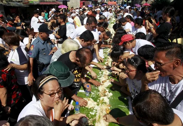Residents participate in a boodle feast serving hundreds of Balut, a local delicacy of boiled duck embryo, during an attempt to make a Guinness World Record in the Pateros municipality, metro Manila April 10, 2015. (Photo by Romeo Ranoco/Reuters)