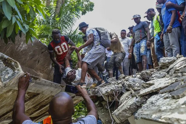 People recover the body of Jean Gabriel Fortune, a longtime lawmaker and former mayor of Les Cayes, from the rubble of the Hotel Le Manguier destroyed by the earthquake in Les Cayes, Haiti, Saturday, August 14, 2021. A 7.2 magnitude earthquake struck Haiti on Saturday, with the epicenter about 125 kilometers ( 78 miles) west of the capital of Port-au-Prince, the US Geological Survey said. (Photo by Ralph Tedy Erol/AP Photo)