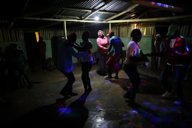 Residents dance at a bar in Boucan Ferdinand, Haiti, April 8, 2018. Sunday evening is the only time when the bar is open and residents gather there to socialise and dance. (Photo by Andres Martinez Casares/Reuters)