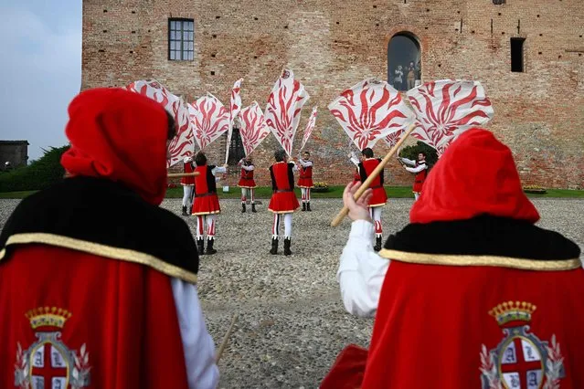 Flag-wavers in medieval period costume perform during a parade at the Castle of Grinzane Cavour, northern Italy, on November 13, 2022, within the 23rd Alba White Truffle World auction. (Photo by Vincenzo Pinto/AFP Photo)