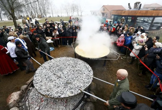 Employees prepare dranik, a potato pancake that is the national dish of Belarus, in the Sula History Park near the village of Sula, Belarus March 7, 2016. (Photo by Vasily Fedosenko/Reuters)
