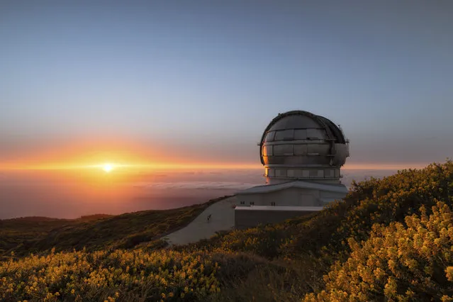 In this image released on Wednesday, July 11, 2018, the sun sets next to the Gran Telescopio Canarias at the Roque de los Muchachos Observatory on the island of La Palma in the Canaries, Spain. On July 27th Mars will be nearing the closest it's been to Earth in 15 years. This event, occurring in parallel to the longest lunar eclipse of the 21st century, creates a unique experience offered to six guests on Airbnb to visit the telescope and view the night sky from one of the best stargazing spots on the planet. (Photo by Antoni Cladera/Airbnb via AP Images)