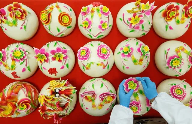 A pastry chef makes decorated steamed buns (aka Huamo) at a pastry store ahead of the Year of the Dragon on January 30, 2024 in Qingdao, Shandong Province of China. (Photo by VCG/VCG via Getty Images)