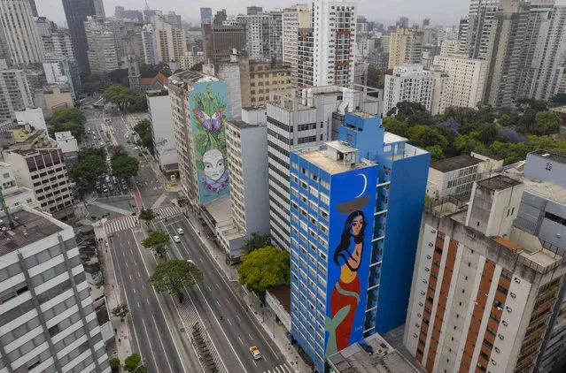 Giant murals created by artists Speto, right, and Cadumen, are displayed on buildings walls in Sao Paulo, Brazil, Wednesday, September 29, 2021. Top muralists have deployed around Sao Paulo participating in a week-long festival with giant paintings of their best work, turning what once was sanctioned graffiti into art works. (Photo by Andre Penner/AP Photo)