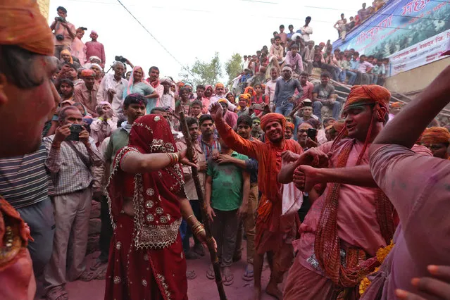 Hindu devotees take part in the religious festival of Lathmar Holi, where women beat the men with sticks, in the town of Barsana in the Uttar Pradesh region of India, March 17, 2016. (Photo by Cathal McNaughton/Reuters)