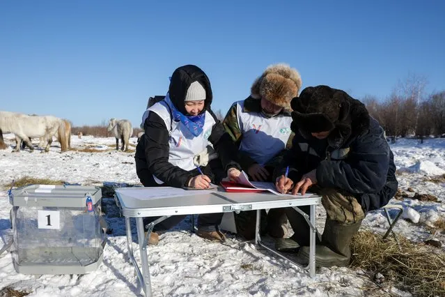 A man votes at an outdoor polling station in the village of Ulakhan-An, a remote area of the Republic of Sakha (Yakutia) on February 25, 2024, during an early voting held as part of the Russian presidential election scheduled for March 15-17, with LDPR Leader Leonid Slutsky, Russian Communist Party member Nikolai Kharitonov, New People Party member Vladislav Davankov, and incumbent president Vladimir Putin listed as candidates. (Photo by Vadim Skryabin/TASS)