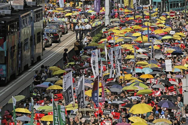 Thousands of protesters march along a downtown street against the extradition law in Hong Kong Sunday, April 28, 2019. The protesters expressed their concerns about the proposed new extradition law that would make it possible for people to be sent to mainland China to face the justice system there. (Photo by Vincent Yu/AP Photo)